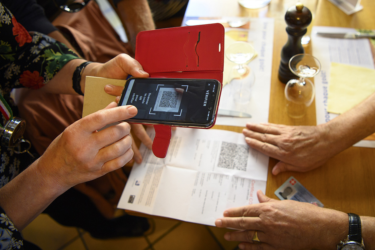 Eine Kellnerin prüft am 13. September 2021 im Café-Restaurant L'Europe in Lausanne mit einem Smartphone das COVID-Zertifikat eines Kunden. Seit dem 13. September 2021 gilt national die vom Bundesrat beschlossene erweiterte Zertifikatspflicht. Foto: Keystone-SDA / Laurent Gilliéron Eine Kellnerin prüft am 13. September 2021 im Café-Restaurant L'Europe in Lausanne mit einem Smartphone das COVID-Zertifikat eines Kunden. Seit dem 13. September 2021 gilt national die vom Bundesrat beschlossene erweiterte Zertifikatspflicht. Foto: Keystone-SDA / Laurent Gilliéron