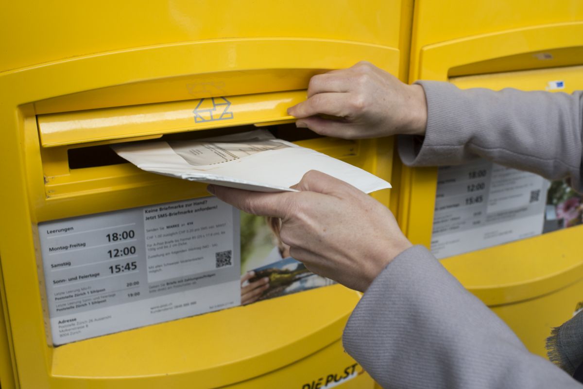 [Symbolbild] Eine Frau wirft am 6. Februar 2016 anlässlich der Kundgebung gegen die SVP-Durchsetzungs-Initiative in Zürich, Schweiz, ihre Abstimmungsunterlagen in einen Briefkasten ein. Die Post ist gesetzlich ans Briefgeheimnis gebunden und hat keine Befugnis, Abstimmungscouverts zu öffnen. Foto: Keystone-SDA / Ennio Leanza