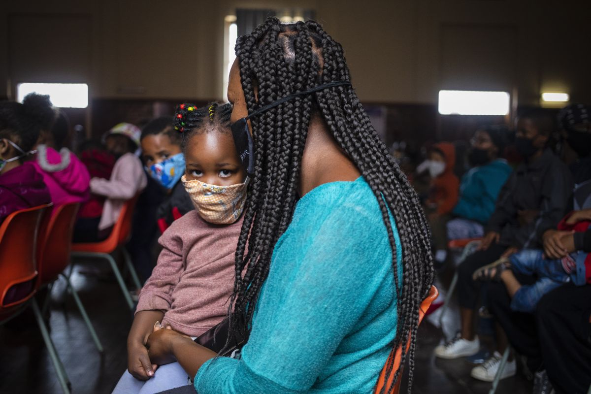 [Symbolbild] Eine Mutter und ihr Kind warten am 23. Dezember 2020 auf eine Essensausgabe der NGO «Hunger has no religion» in Johannesburg, Südafrika. Humanitäre Organisationen wiesen während der Corona-Pandemie mehrfach auf die sich ausbreitende Hungersnot hin. Foto: Keystone-SDA / EPA / Kim Ludbrook   