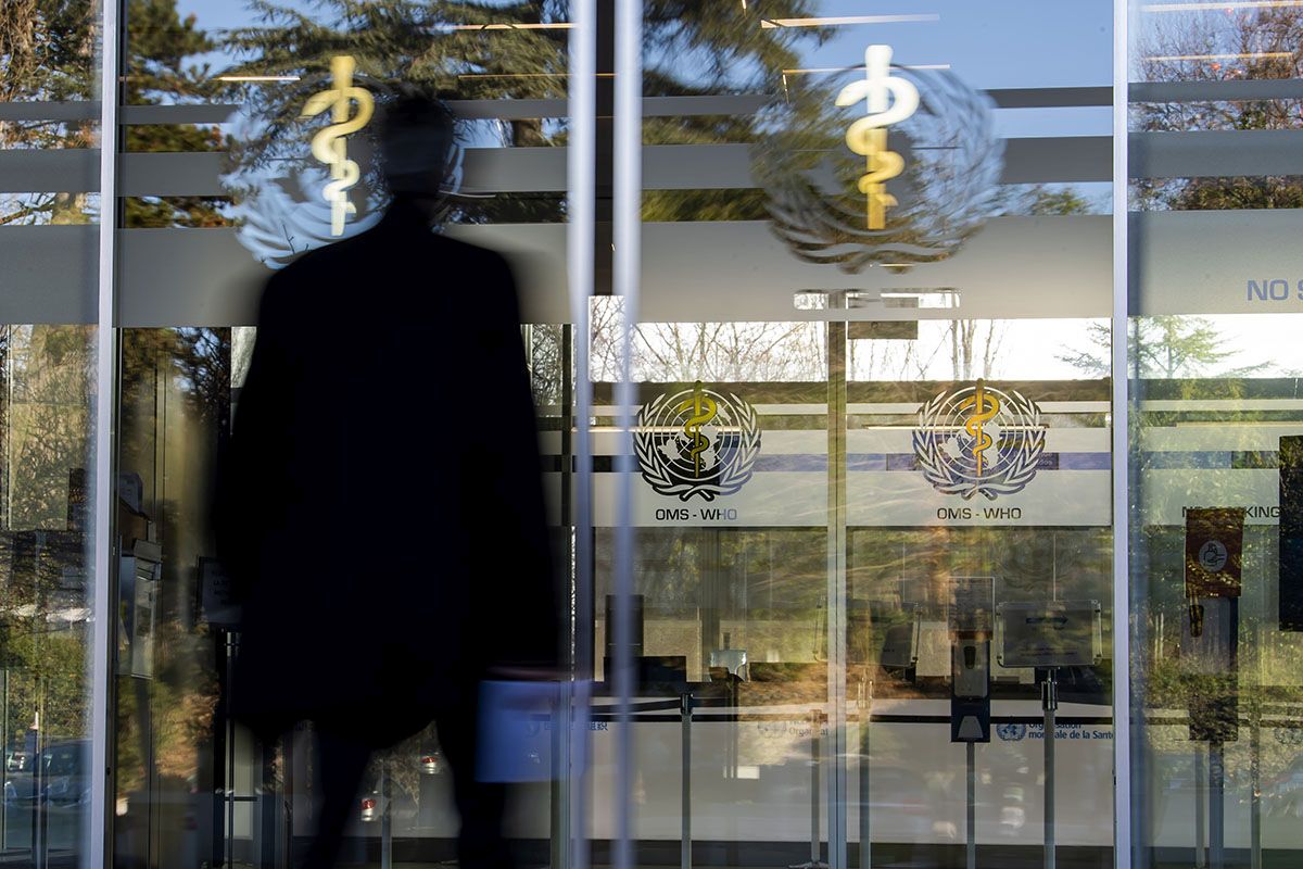 Ein Mann am Eingang zum Hauptgebäude der Weltgesundheitsorganisation (WHO) in Genf, 5. Januar 2022. Foto: Keystone-SDA / Martial Trezzini  
