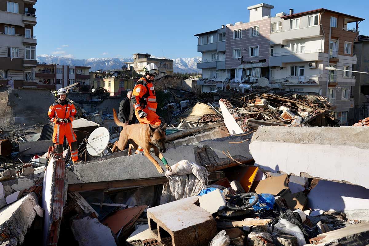 Mitarbeiter der Schweizer Rettungskette suchen am 8. Februar 2023 im Erdbebengebiet von Hatay in der Osttürkei mit einem Rettungshund nach Überlebenden. Foto: KEYSTONE/EDA/Michael Fichter