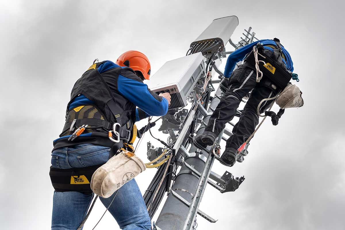 Zwei Mitarbeiter des Unternehmens Axians installieren am 5. April 2019 im Kanton Genf eine 5G-Antenne für die Mobilkommunikation auf einem Mast auf dem Dach eines Gebäudes im Viertel La Gradelle in Chene-Bougeries. Foto: Keystone-SDA / Martial Trezzini Zwei Mitarbeiter des Unternehmens Axians installieren am 5. April 2019 im Kanton Genf eine 5G-Antenne für die Mobilkommunikation auf einem Mast auf dem Dach eines Gebäudes im Viertel La Gradelle in Chene-Bougeries. Foto: Keystone-SDA / Martial Trezzini