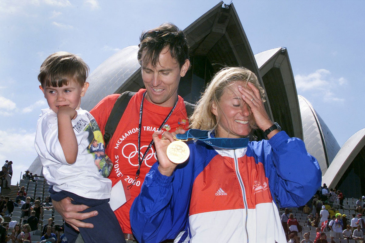 2674795 - Keystone-SDA/Fabrice Coffrini - Brigitte McMahon präsentiert im August 2000 zusammen mit ihrer Familie die Goldmedaille vor dem Opernhaus in Sydney. Kurz zuvor war die Zugerin zur ersten Olympiasiegerin im Triathlon gekürt worden.