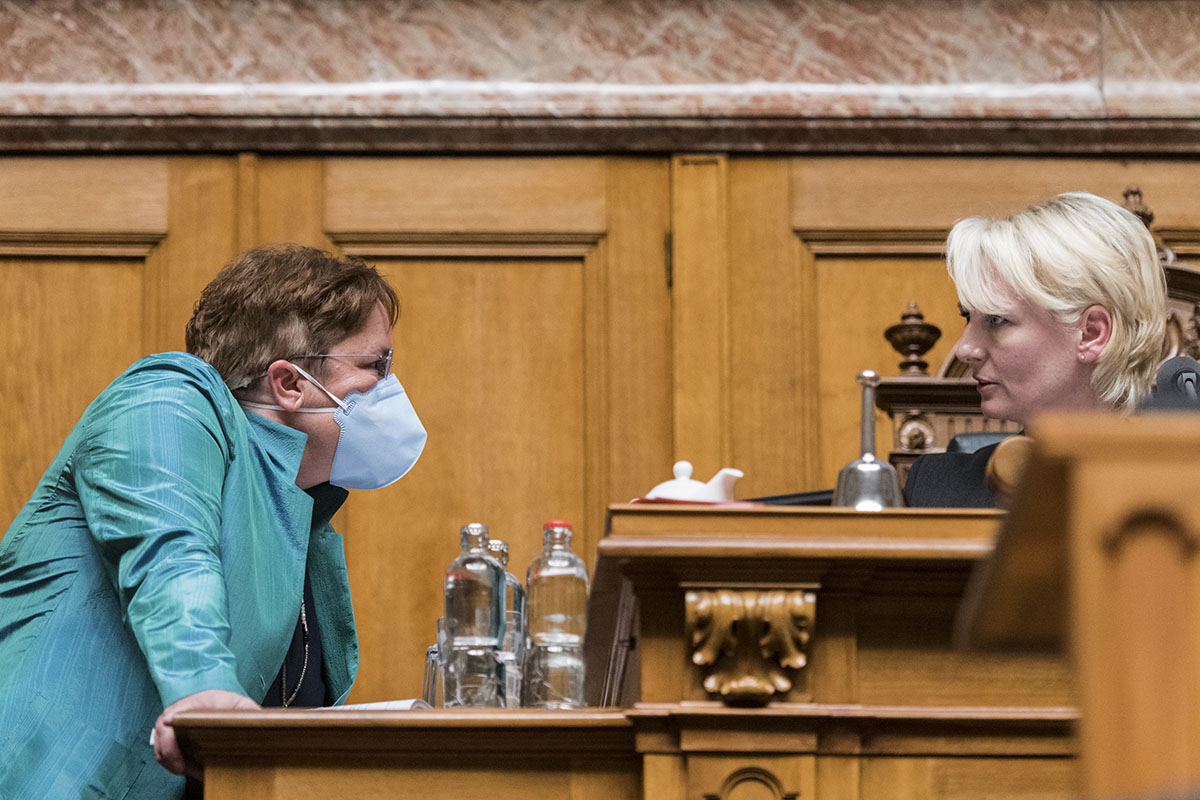 410280097 – Keystone-SDA/Alessandro della Valle  - Magdalena Martullo-Blocher, SVP-GR, links, eine Atemschutzmaske tragend, diskutiert am 2. März 2020 mit der Ratspräsidentin Isabelle Moret, FDP-VD, am ersten Tag der Frühlingssession der Eidgenössischen Räte in Bern. 