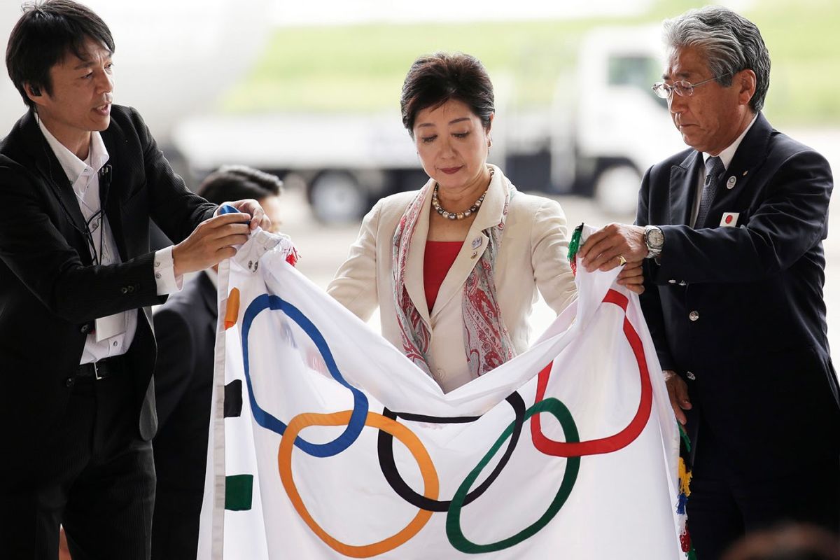 La gouverneure de Tokyo Yuriko Koike (au centre) déploie le drapeau olympique avec le président du Comité olympique japonais (JOC) Tsunekazu Takeda (à droite) lors de la cérémonie d'arrivée du drapeau olympique à Tokyo, le 24 août 2016. Photo : epa/ Kiyoshi Ota La gouverneure de Tokyo Yuriko Koike (au centre) déploie le drapeau olympique avec le président du Comité olympique japonais (JOC) Tsunekazu Takeda (à droite) lors de la cérémonie d'arrivée du drapeau olympique à Tokyo, le 24 août 2016. Photo : epa/ Kiyoshi Ota