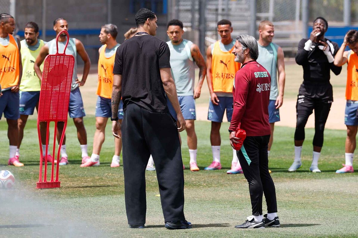 NBA basketball player Yanic Konan Niederhaeuser, left, talks to Switzerland's head coach Murat Yakin during his visit at a training session of the Swiss national soccer team