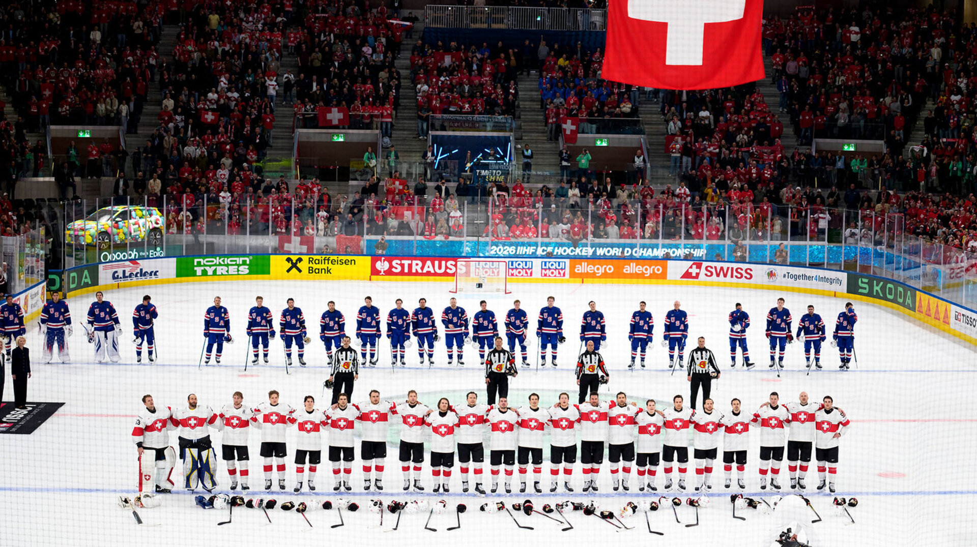 Switzerland's players celebrate the victory under theSwiss flag after the 2026 IIHF Men's Ice Hockey World Championship preliminary round group A game between United States and Switzerland
