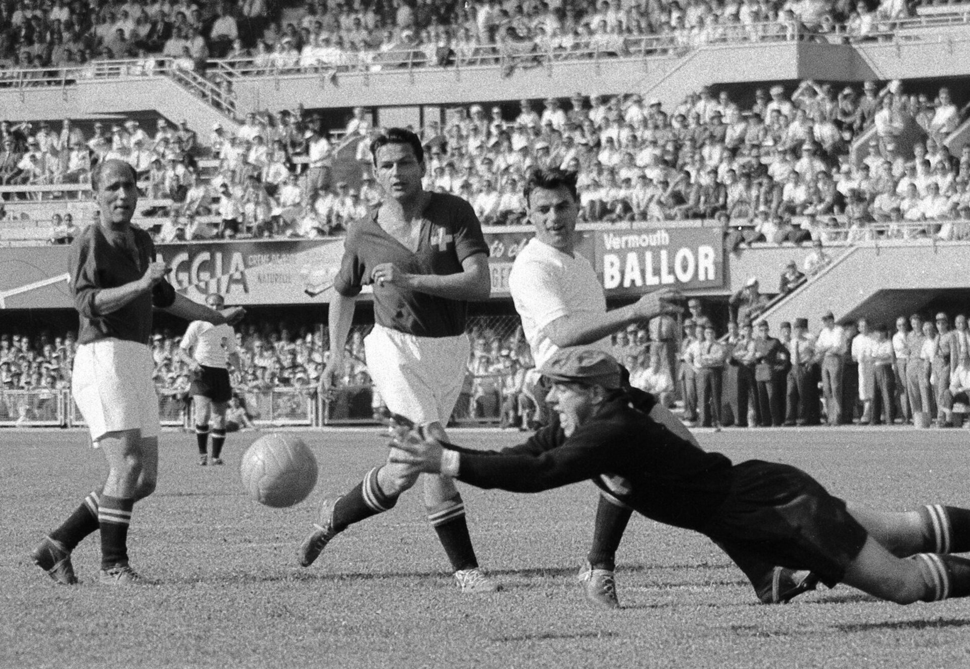 Unterstuetzt von Oliver Eggimann, links, und Roger Bocquet, Mitte, verrichtet der Schweizer Torhueter Eugene Parlier vorzuegliche Abwehrarbeit vor dem heranstuermenden Oesterreicher Theodor Wagner im Viertelfinal der Fussball-Weltmeisterschaft zwischen Schweiz und Oesterreich.