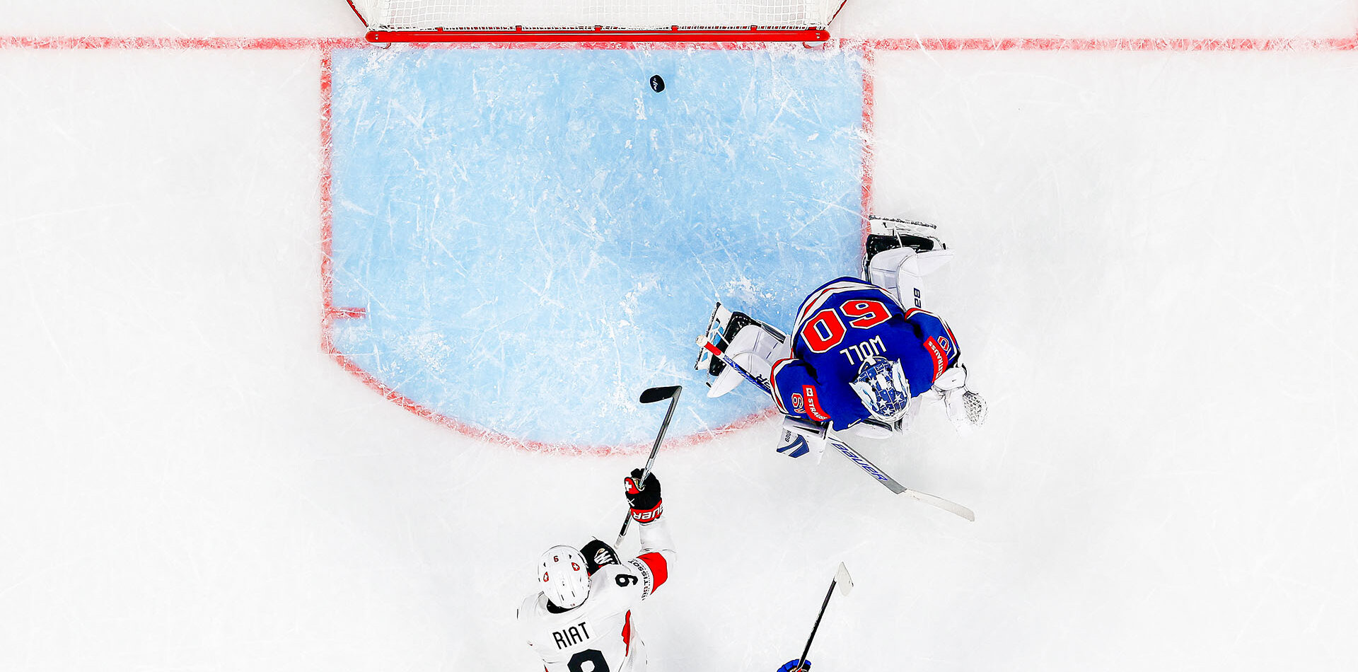 USA's goaltender Joseph Woll, right, fails to save the third goal of Team Switzerland Switzerland's Ken Jager, next to Switzerland's Damien Riat, center, and USA's Wyatt Kaiser, bottom right, during the 2026 IIHF Men's Ice Hockey World Championship preliminary round group A game between United States and Switzerland