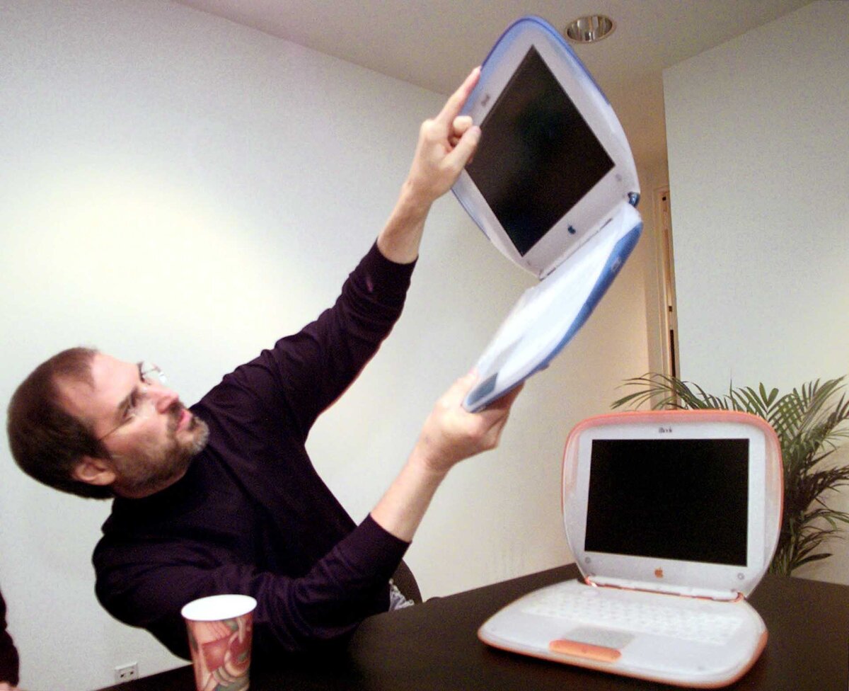 Founder and Acting CEO of Macintosh Steve Jobs shows off the company's new consumer laptop called "iBook" after his keynote address at the Macworld Expo in New York