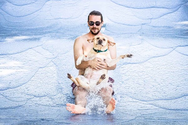 Fabian and his dog Meyla on the water slide on the season's last day at the Toess public outdoor pool in Winterthur