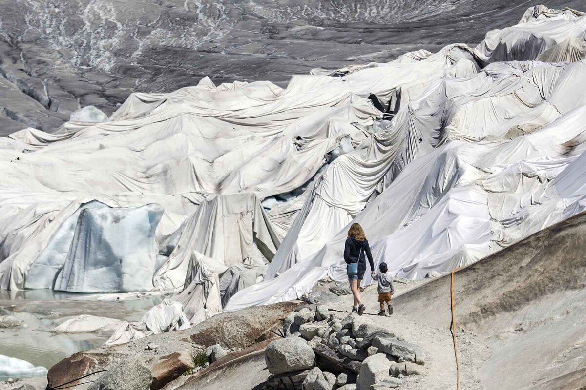 People visit the Rhone Glacier covered in blankets above Gletsch near the Furkapass in Switzerland