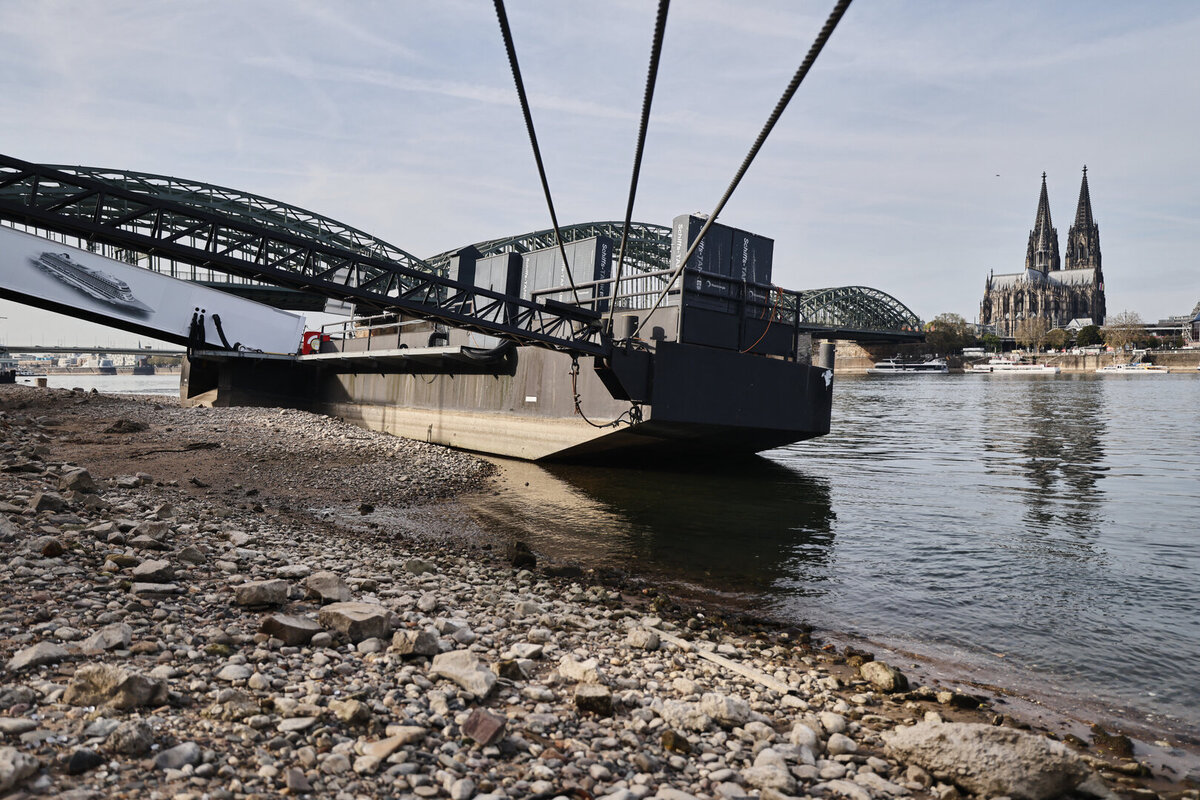 Ein Schiffsanleger liegt am Rheinufer in Köln auf Grund. Die außerordentlich niedrigen Pegelstände am Rhein erschweren weiter den Schiffsverkehr.