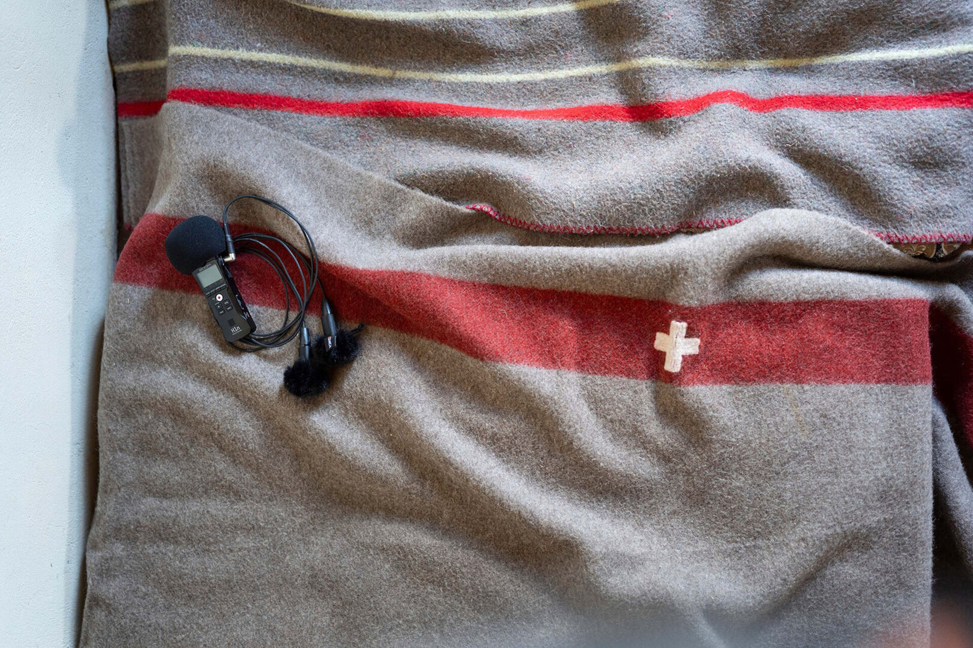 Un micro et un enregistreur sont poses sur une couverture suisse.