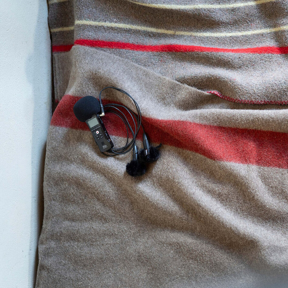 Un micro et un enregistreur sont poses sur une couverture suisse.