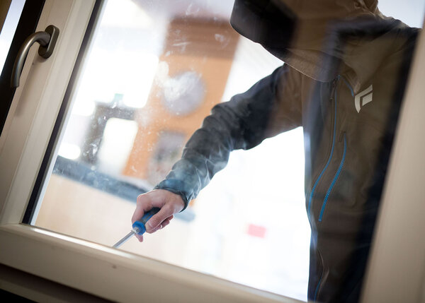 ILLUSTRATION - Ein Mann demonstriert in der polizeilichen Beratungsstelle, wie einfach es für einen Einbrecher wäre, mit Hilfe eines stabilen Schraubenziehers ein geschlossenes Fenster von außen zu öffnen.