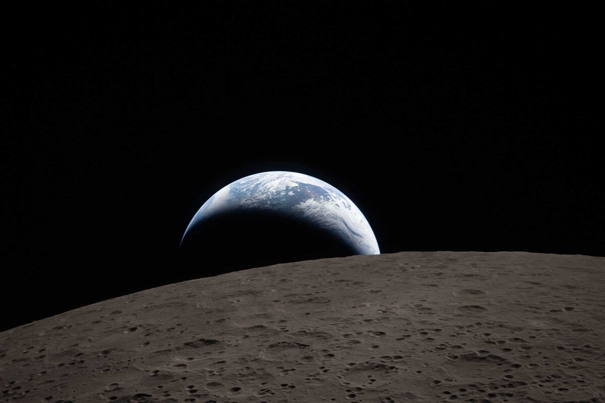 A handout picture made available by the National Aeronautics and Space Administration (NASA) shows Earthset captured through the Orion spacecraft window at 6:41 p.m. EDT, 06 April 2026, during the Artemis II crew's flyby of the Moon. In the foreground, Ohm crater has terraced edges and a flat floor interrupted by central peaks.
