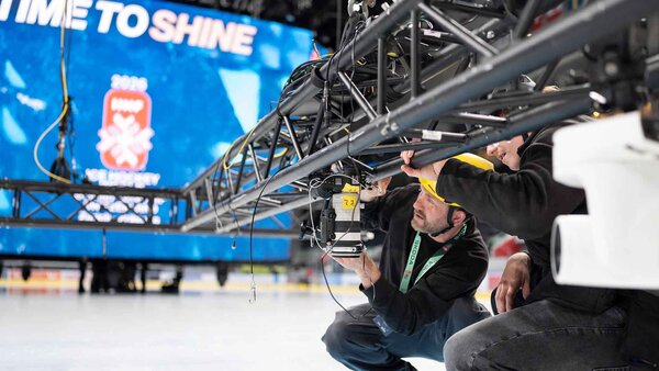 Claudio Thoma, wearing the black helmet, and Michael Buholzer, wearing the yellow helmet, both Keystone-SDA photographers are setting up a camera with a remote shutter release and transmitter, which will remain mounted on the ceiling of the Swiss Life Arena for the duration of the Ice Hockey World Championship