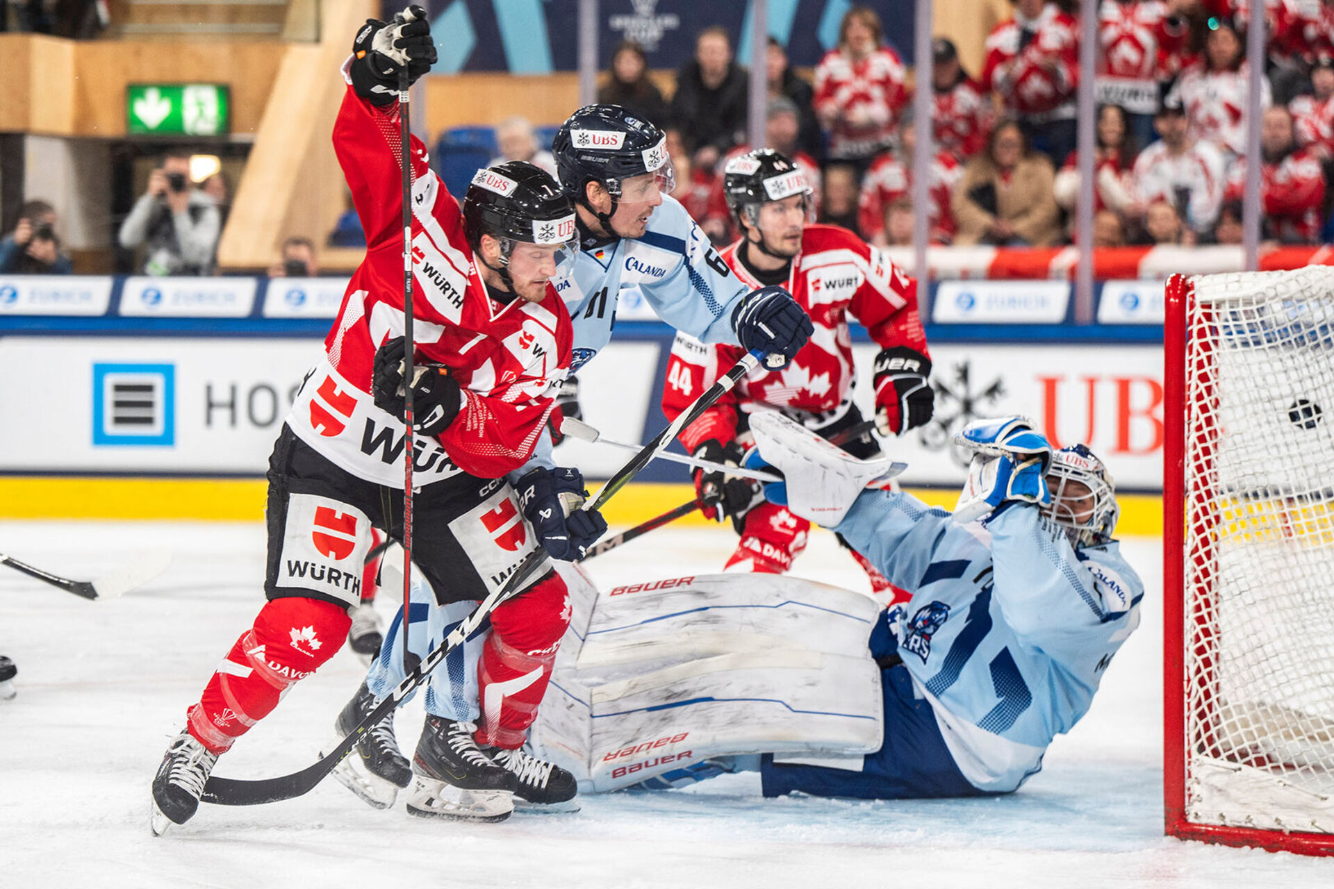 Daniel Carr de Team Canada (a gauche) marque le 2-1 contre Zane McIntyre de Straubing (a droite) lors de la demi-finale entre Team Canada et les Straubing Tigers (Allemagne), au 96e tournoi de hockey sur glace de la Coupe Spengler.