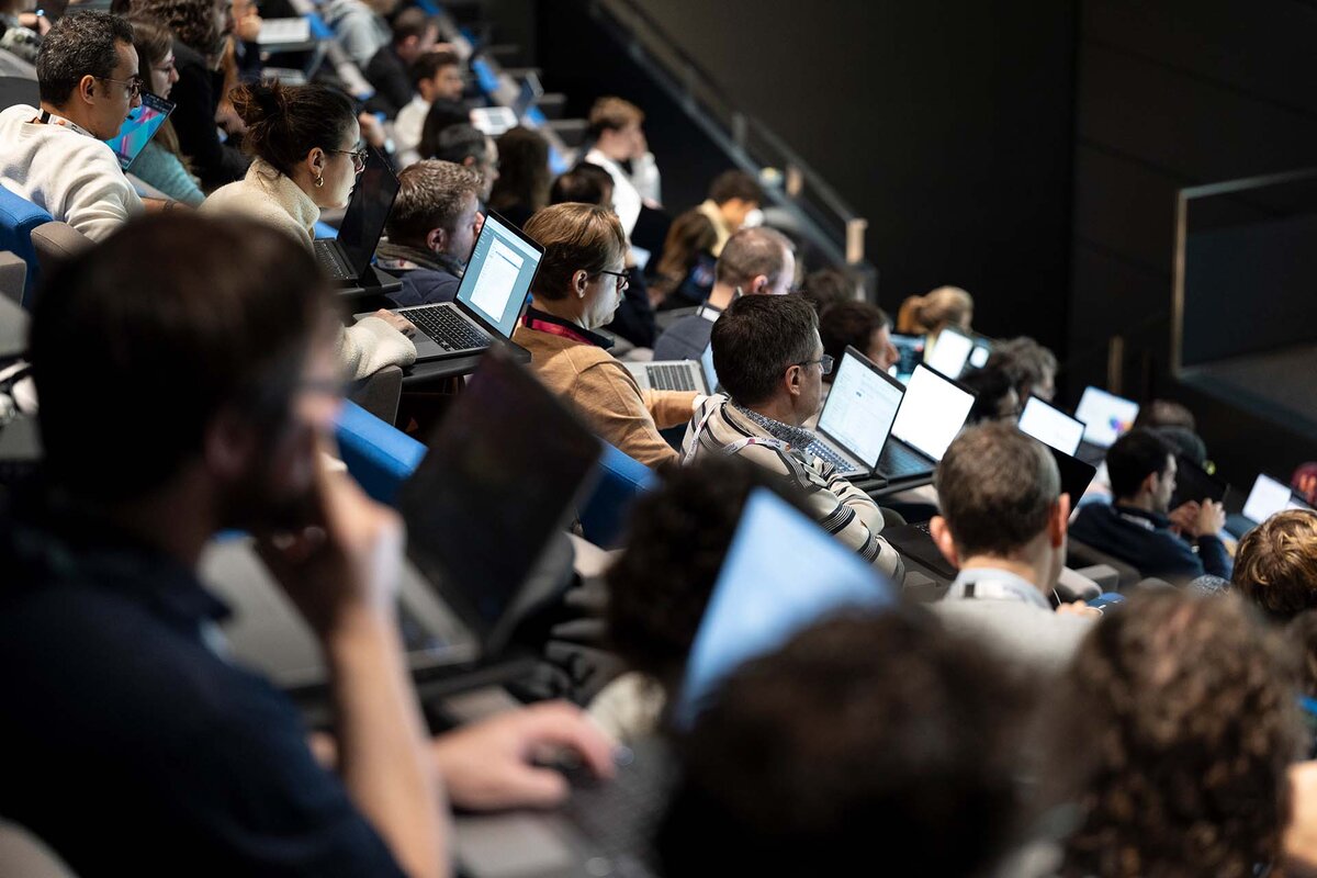Teilnehmer eines Workshops im Rahmen der 'Applied Machine Learning Days AMLD 2026' der EPFL zum Thema KI und schreiben Codes auf ihren Laptops