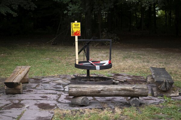 Eine Grillstelle in einem Schweizer Wald ist gesperrt. Ein gelbes Warnschild weist auf das absolute Feuerverbot hin, und ein rot-weisses Absperrband blockiert den Zugang zum Grillrost,, nahe Recherswil (SO) am Dienstag, 14. Juli 2026. Wegen der anhaltenden Hitzewelle und des extremen Trockenwetterstresses hat der Kanton Solothurn diese strengen Massnahmen (Waldbrandgefahr der Stufe 4) ergriffen, um Wald- und Flurbraende zu verhindern.