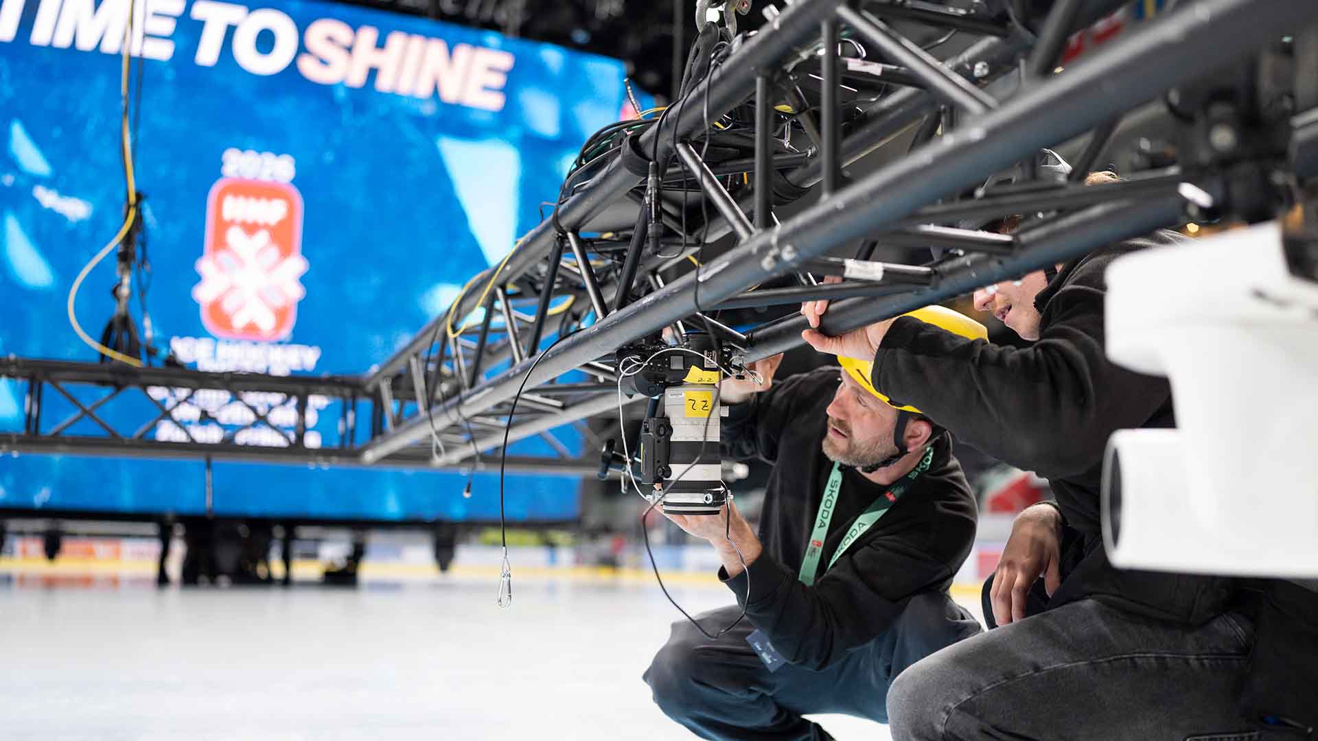 Claudio Thoma, wearing the black helmet, and Michael Buholzer, wearing the yellow helmet, both Keystone-SDA photographers are setting up a camera with a remote shutter release and transmitter, which will remain mounted on the ceiling of the Swiss Life Arena for the duration of the Ice Hockey World Championship