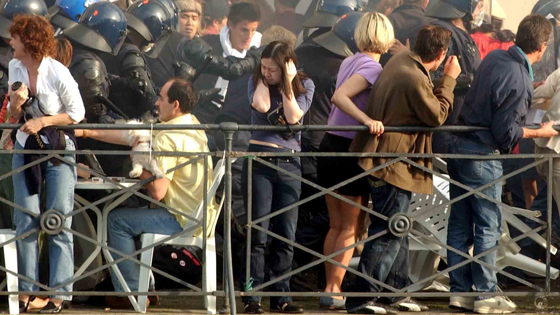 Police officers try to follow rioters escaping over the terrasse of a restaurant in downtown Geneva, Sunday, June 1, 2003