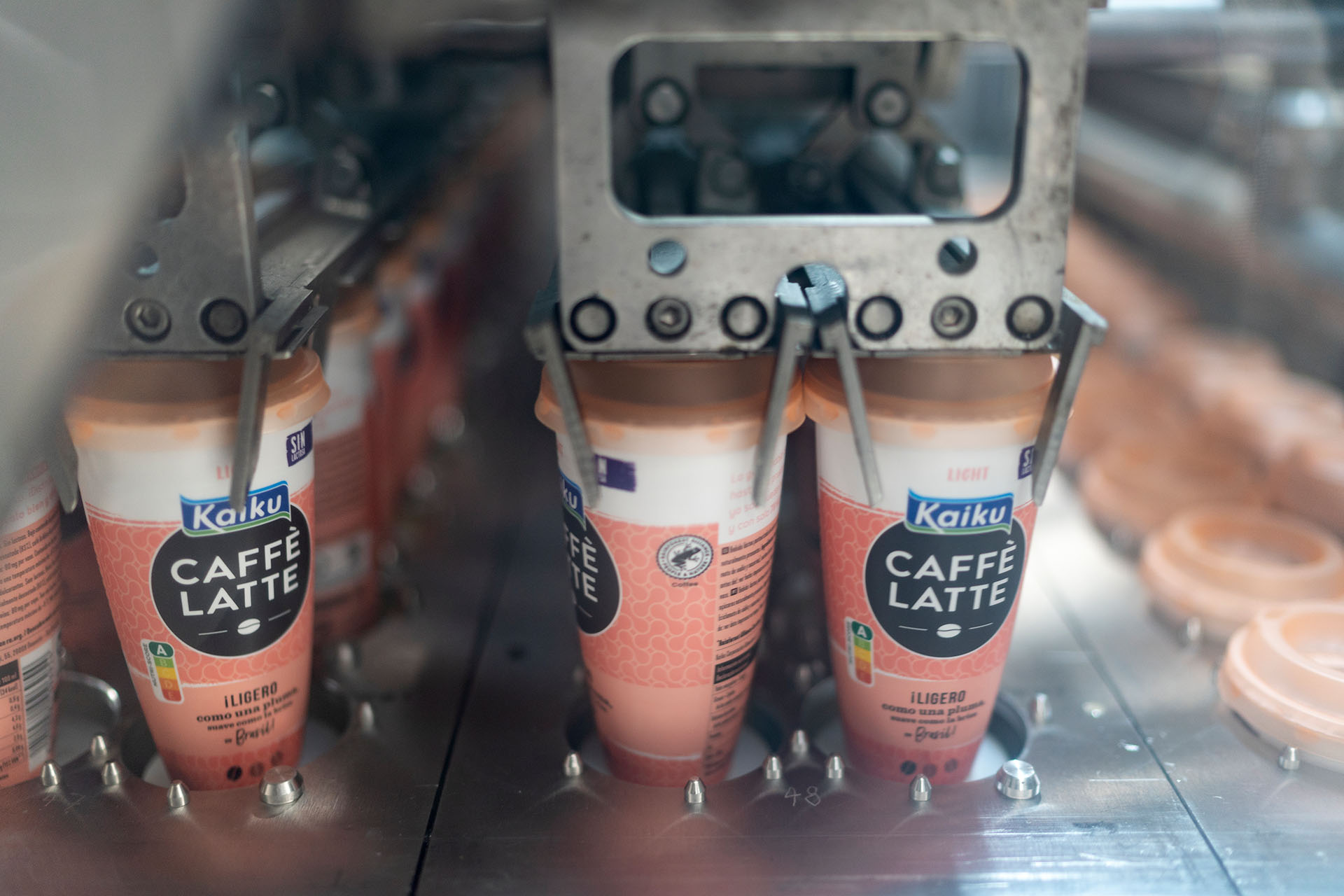 Plastikbecher werden in der Abfuellanlage von Emmi unter dem Namen Kaiku Caffe Latte fuer den spanischen Markt mit Caffe Latte befuellt